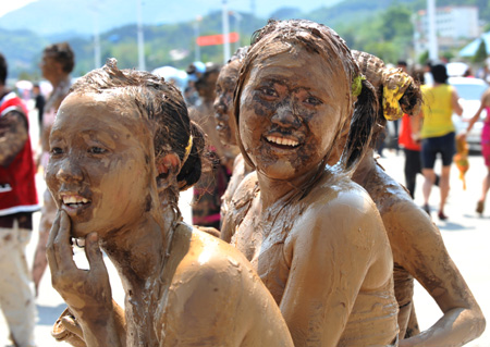 Two girls of the Va ethnic group are seen covered with clay during a carnival at the Va Ethnic Autonomous Prefecture of Cangyuan, southwest China's Yunnan Province, May 2, 2009. During the 4-day festival, people daubing each other with the clay made of natural material, to express wishes of health and happiness. (Xinhua/Chen Haining) 