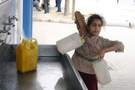 A Palestinian girl fetches drinking water with plastic barrels in the war-battered southern Gaza Strip town of Rafah, near the border with Egypt, on May 2, 2009. 