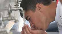 A Palestinian man drinks water under a water faucet in the war-battered southern Gaza Strip town of Rafah, near the border with Egypt, on May 2, 2009.