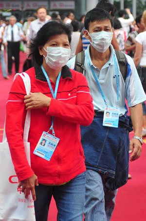 Visitors wear masks during the third phase of the 105th Canton Fair in Guangzhou, capital of south China's Guangdong Province, May 3, 2009. The third phase of the 105th Canton Fair, China's largest trade event, began on Sunday with preventive measures against the A/H1N1 flu. 