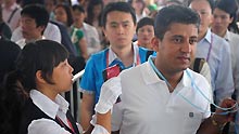 A staff member checks a visiter's body temperature during the third phase of the 105th Canton Fair in Guangzhou, capital of south China's Guangdong Province, on May 3, 2009.