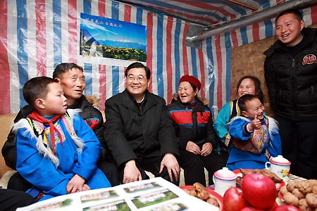 Chinese President Hu Jintao (3rd L) smiles as he talks with family members of Ma Xizhi (2nd L) at Caijiagang Village of Xuankou Township in Wenchuan County, southwest China's Sichuan Province, Dec. 29, 2008. President Hu Jintao visited quake-hit Sichuan Province on Dec. 27-29, showing concern for survivors and inspecting reconstruction work. 