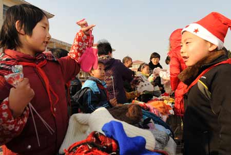 Pupils sell goods at a campus charity bazaar held at a primary school in Wuxi, east China's Jiangsu Province, on December 31, 2008. The money raised from the charity bazaar will be donated to the pupils in the earthquake-hit area in Sichuan Province and children of migrant workers.