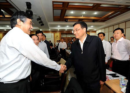 Chinese Vice Premier Li Keqiang (R, front) shakes hands with an expert on prevention and control of A/H1N1 Flu prior to a symposium at the Ministry of Health in Beijing, on May 4, 2009. 