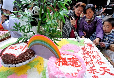 Local people delivers cake for giant panda in Fuzhou, southeast China's Fujian Province, on December 28, 2008. Fuzhou citizens held a happy New Year party for the Giant Pandas, which were transferred to Fuzhou from Sichuan Province after the disastrous earthquake on Sunday.