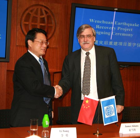 Mr. James Adams (R) shakes hands with Mr. Li Yong after signing the legal documents for the Wenchuan Earthquake Recovery Project. The World Bank and the Chinese Government signed a US$710 million loan agreement for the project in Beijing on March 20, 2009. [China Development Gateway]