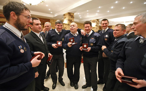 Staff of Russia's Ministry of Emergency Situations celebrate after receiving souvenir badges in Moscow on December 24, 2008. Chinese Ambassador to Russia Liu Guchang award 98 working staff of the ministry on Tuesday for their great jobs in the rescue work after Wenchuan earthquake hit China's Sichuan Province in May, 2008.