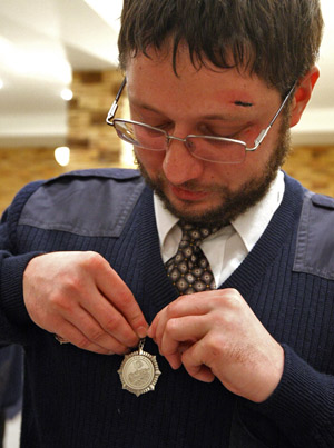 A staff member of Russia's Ministry of Emergency Situations tidies his badge in Moscow on December 23, 2008. 