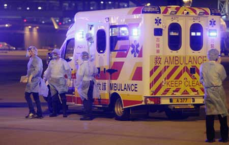 A Mexican tourist (L) wearing surgical suit steps down the ambulance and heads for the charter flight at Hong Kong International Airport in Hong Kong, south China, on May 6, 2009. 