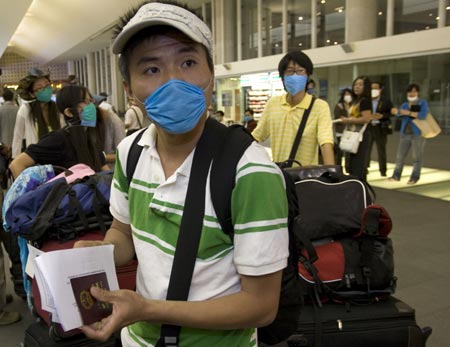 Chinese citizens wait for boarding at Benito Juarez international airport in Mexico City, capital of Mexico, on May 5, 2009. A total of 79 Chinese citizens left Mexico City early Tuesday aboard a chartered flight sent by the Chinese government. The plane took off from Mexico City, heading towards Tijuana, northern Mexico, to lift 20 more Chinese before returning to China.