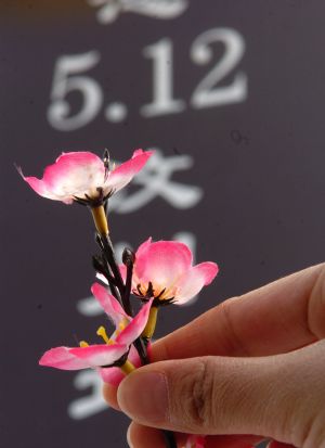 A resident presents flowers to a monument for victims in the devastating earthquake striking southwest China's Sichuan Province May 12, 2008, in Xining, northwest China's Qinghai Province, April 4, 2009. A public memorial service was held here on Saturday for victims in last year's dissolving earthquake during the traditional Qingming Festival or Tomb-sweeping Day. (Xinhua/Yang Shoude)