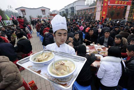 A boy serves during a banquet to celebrate moving into new house in Dongjiaxinyuanzi town of Dujiangyan City, southwest China's Sichuan Province, on January 22, 2009. As their homestead was destroyed in the earthquake in May 2008, about 400 families in Dongjiaxinyuanzi town moved to new houses on January 22. 