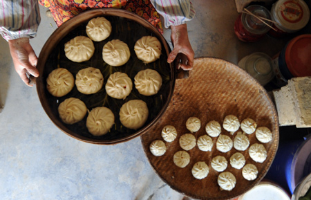 A woman prepares stuffed steamed buns for the coming Spring Festival in Wenxian County of Longnan City, northwest China's Gansu Province, on January 24, 2009.