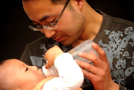 Li Yongbing feeds his son Li Zihao with milk at home in Fuxin Township, Mianzhu City, Sichuan Province, southwest China, on May 1, 2009. 