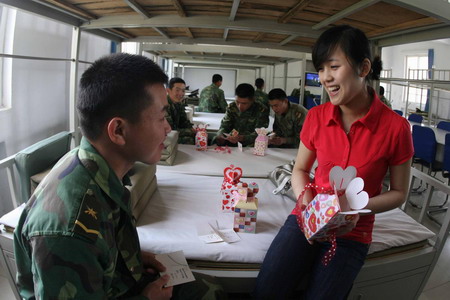 Earthquak survivor Song Yanmei (R) chats with a military soldier in Luoyang, capital city of central China's Henan Province, on May 6, 2009. The military unit discovered and rescued Song from collapsed houses in Yingxiu township of Wenchuan county, the epicenter of last year's devastating earthquake. As the anniversary is approaching, Song comes all the way from southwest China to express her gratitude and blessing for her life savers.