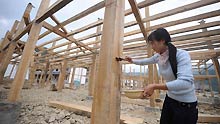 A villager paint the columns at a construction site of houses in Qingchuan county, southwest China's Sichuan Province, on May 6, 2009.