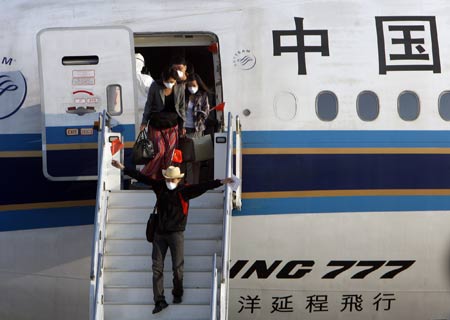 Passengers go off from the chartered plane from Mexico after the plane arrived at Pudong International Airport in Shanghai, east China, on May 6, 2009. 