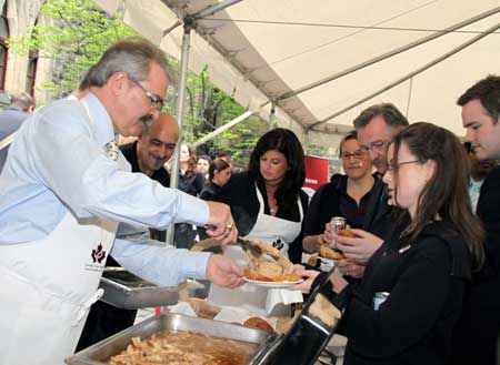 Canadian Agriculture Minister Gerry Ritz (1st L) gives out pork burgers to government officials at a pork BBQ luncheon on Parliament Hill in Ottawa, capital of Canada, on May 6, 2009. Ritz stressed here on Wednesday that Canadian pork is safe while urging domestic consumers to eat more pork to help the struggling pork industry, hard-hit by bans from foreign countries following the outbreak of influenza A/H1N1.