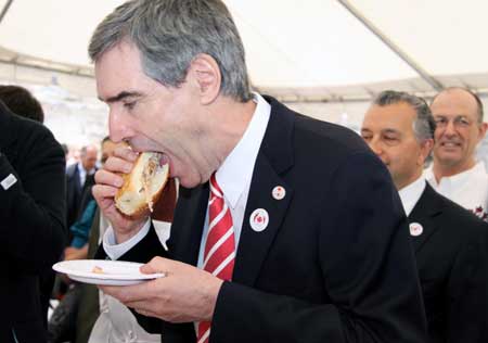 Leader of Canada's Liberal Party Michael Ignatieff eats a pork burger given by Canadian Agriculture Minister Gerry Ritz at a pork BBQ luncheon on Parliament Hill in Ottawa, capital of Canada, on May 6, 2009. Ritz stressed here on Wednesday that Canadian pork is safe while urging domestic consumers to eat more pork to help the struggling pork industry, hard-hit by bans from foreign countries following the outbreak of influenza A/H1N1.