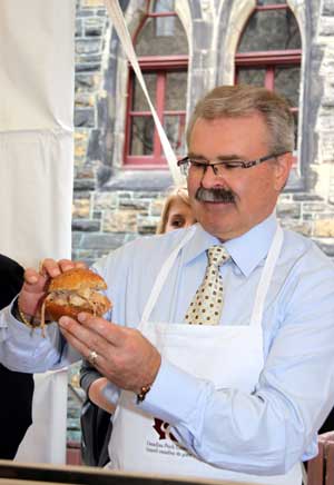 Canadian Agriculture Minister Gerry Ritz gives out pork burgers to government officials at a pork BBQ luncheon on Parliament Hill in Ottawa, capital of Canada, on May 6, 2009. Ritz stressed here on Wednesday that Canadian pork is safe while urging domestic consumers to eat more pork to help the struggling pork industry, hard-hit by bans from foreign countries following the outbreak of influenza A/H1N1.