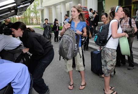 Canadian students (front) who took a flight to Changchun on May 2 from Canada via Beijing for exchange studies, carry their baggages as the quarantine ends in Changchun, capital of northeast China's Jilin Province, on May 7, 2009. 