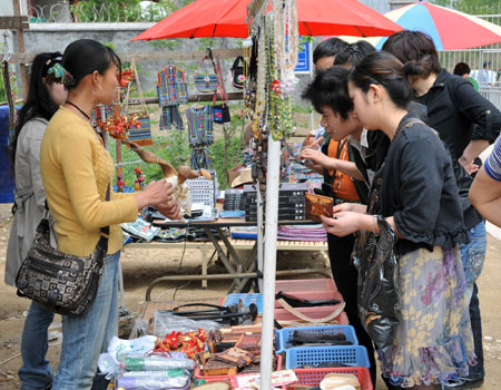 Tourists select souvenirs at a market stall near the old Beichuan County, Mianyang City, southwest China's Sichuan Province, on May 1, 2009. 