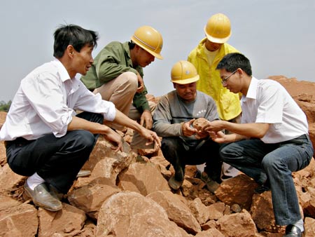 Working staff of the Nankang Museum inspect a construction site where dinosaur egg fossils were found in Nankang, east China's Jiangxi Province, on May 6, 2009. Some 22 round dinosaur egg fossils, with the diameter of 10-12 centimeters, were found here recently.