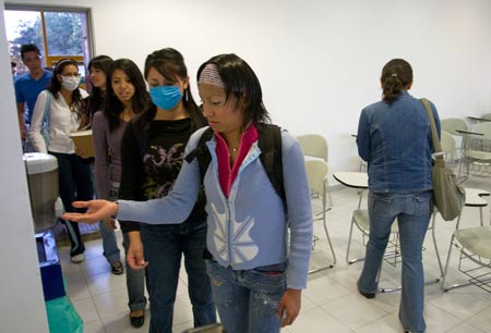 Students spray hand sanitizer before attending classes at the National Autonomous University of Mexico (NAUM) in the Mexico City on May 7, 2009. All high schools and universities in Mexico resumed classes on Thursday as the government said the worst of the flu crisis is over. 