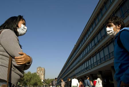 Two students wearing masks greet each other at the National Autonomous University of Mexico (NAUM) in the Mexico City on May 7, 2009. 