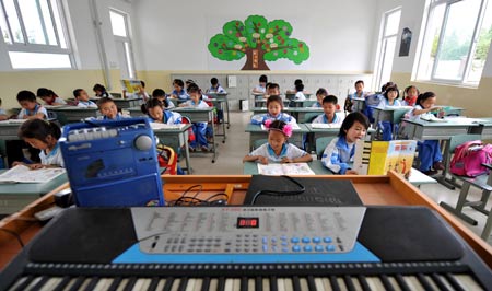 Pupils attend a music class at a primary school in Chongyi Town of Dujiangyan City, southwest China's Sichuan Province, May 9, 2009. The school, reconstructed after the deadly May 12 earthquake last year with the aid of Shanghai Municipality in east China, can resist magnitude-8.0 quake. (Xinhua/Yang Lei)