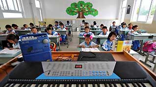 Pupils attend a music class at a primary school in Chongyi Town of Dujiangyan City, southwest China's Sichuan Province, on May 9, 2009. The school, reconstructed after the deadly May 12 earthquake last year with the aid of Shanghai Municipality in east China, can resist magnitude-8.0 quake.