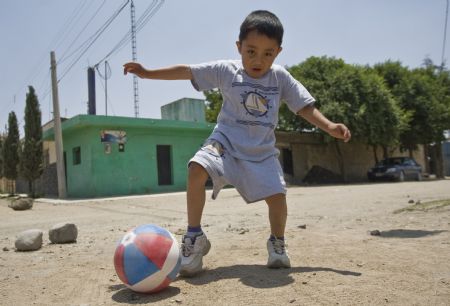 The first A/H1N1 flu patient Edgar Hernandez plays a ball in La Gloria village, Mexico's eastern coast state of Veracruz, on May 8, 2009. Edgar has recovered and led a normal life here.