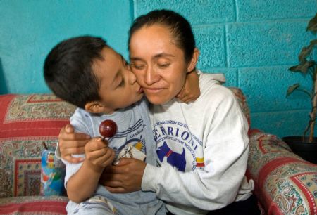 The first A/H1N1 flu patient Edgar Hernandez kisses his mother in La Gloria village, Mexico's eastern coast state of Veracruz, on May 8, 2009. Edgar has recovered and led a normal life here.