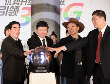 Guests touch a glass ball to launch the 3G service at a launching ceremony in Lhasa, capital of southwest China's Tibet Autonomous Region, on May 9, 2009. The Tibet Mobile of China Mobile hosted the launching ceremony of TD-SCDMA services in the region on Saturday. 