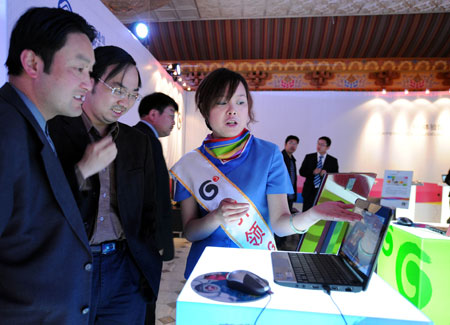 An attendant introduces the 3G service to visitors in Lhasa, capital of southwest China's Tibet Autonomous Region, on May 9, 2009.