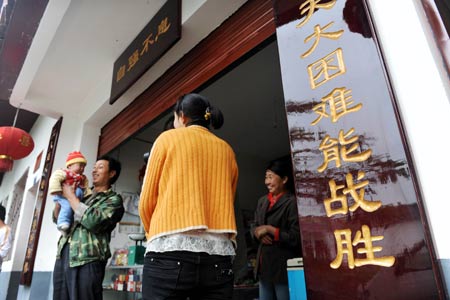 Shi Guangwu's family members chat in front of their store at Zaoshu village of Qingchuan County, southwest China's Sichuan Province, on May 9, 2009. 