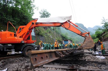 A power excavator relocates the old rails as a large number of constructors converge on the renewal of railroad switch for expedition at the Hengxianhe Station, during an intensive renovation of the Baoji-Chengdu Railway, at Lueyang, northwest China's Shaanxi Province, on May 9, 2009. 