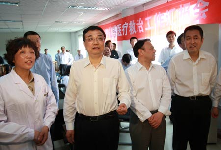 Chinese Vice Premier Li Keqiang (2nd L) communicates with the confirmed A/H1N1 patient through video at the Chengdu Infectious Disease Hospital, which accepted Chinese mainland's first confirmed A/H1N1 patient surnamed Bao, in Chengdu, capital of southwest China's Sichuan Province, on May 11, 2009.