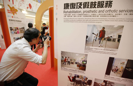 A journalist takes photos at a photo exhibition in Hong Kong, south China, on May 11, 2009. A photo exhibition in memory of the first anniversary of the May 12, 2008 earthquake opened in Hong Kong on Monday. The show displaying photos taken by Hong Kong photographers in the regions hit by the earthquake in Sichuan Province depicted the work of the Hong Kong Red Cross and the process of reconstruction in the quake-hit areas. 