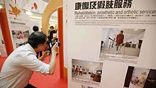 A journalist takes photos at a photo exhibition in Hong Kong, south China, on May 11, 2009. A photo exhibition in memory of the first anniversary of the May 12, 2008 earthquake opened in Hong Kong on Monday. The show displaying photos taken by Hong Kong photographers in the regions hit by the earthquake in Sichuan Province depicted the work of the Hong Kong Red Cross and the process of reconstruction in the quake-hit areas.