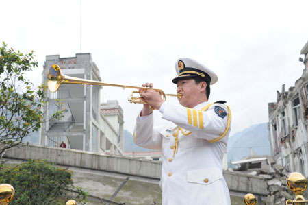 A man plays a trumpet at the beginning of the ceremony to mark the first anniversary of May 12 Earthquake in Yingxiu Township of Wenchuan County, southwest China's Sichuan Province, on May 12, 2009. 
