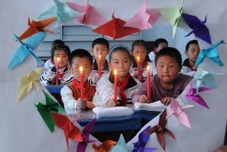 Pupils attend an activity commemorating the victims of the May 12 earthquake last year, at Qiantang Primary School in Harbin, capital of northeast China's Heilongjiang Province, on May 11, 2009. As the first anniversary of the earthquake approaches, people all over China commemorate the disaster in different ways. 