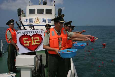 Soldiers spread flower leaves to the sea in commemoration of the victims of the May 12 earthquake last year, during an activity in Sanya, south China's Hainan Province, on May 11, 2009. As the first anniversary of the earthquake approaches, people all over China commemorate the disaster in different ways. 