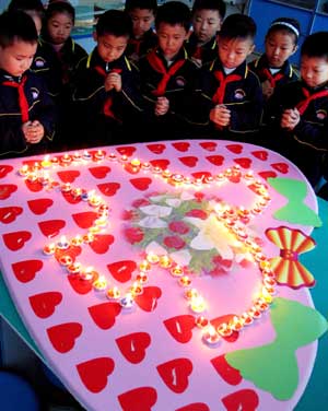 Pupils mourn the victims of the May 12 earthquake last year, during an activity at Daminghu Primary School in Jinan, capital of east China's Shandong Province, on May 11, 2009. As the first anniversary of the earthquake approaches, people all over China commemorate the disaster in different ways. 