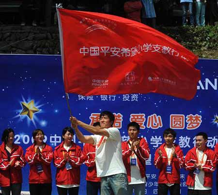 Chinese hurdler Liu Xiang waves a flag at a primary school in quake-hit Beichuan County, southwest China's Sichuan Province, Monday on May 11, 2009.