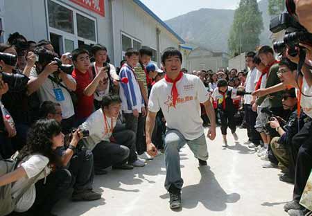 Chinese hurdler Liu Xiang shows quake zone pupils how to hurdle at a primary school in Beichuan County, southwest China's Sichuan Province, on Monday May 11, 2009. 