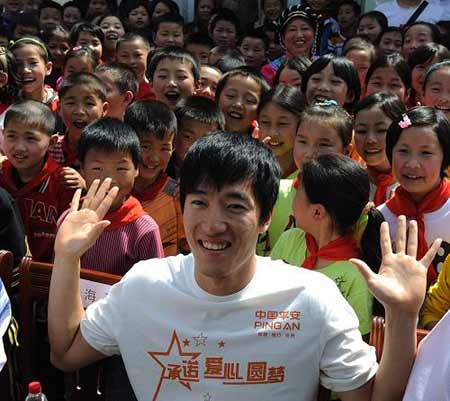 Chinese hurdler Liu Xiang poses for photgraphs with quake zone pupils at a primary school in Beichuan County, southwest China's Sichuan Province, on Monday May 11, 2009.