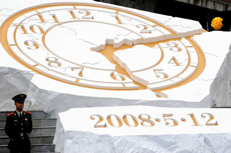 The sculpture of a destroyed clock plate is seen prior to the ceremony to mark the first anniversary of the devastating Wenchuan earthquake in Yingxiu Township of Wenchuan County, southwest China's Sichuan Province, on May 12, 2009. China will mark the anniversary of last year's devastating earthquake Tuesday afternoon with commemorative activities to be held in the epicenter Yingxiu Township. 