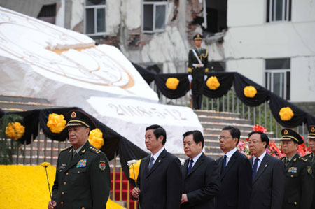 People present flowers during the commemorative service to mark the first anniversary of May 12 Earthquake in Yingxiu Township of Wenchuan County, southwest China's Sichuan Province, on May 12, 2009.