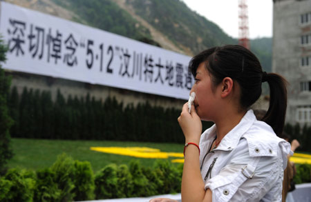 A girl mourns for her relatives in the old county seat of Beichuan, southwest China's Sichuan Province, on May 12, 2009, the first anniversary of the May 12 Wenchuan earthquake.